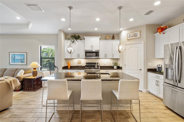 11125 Mcdermott Ct, Englewood, FL 34223 - kitchen with dark countertops, appliances with stainless steel finishes, a sink, open floor plan, and visible vents