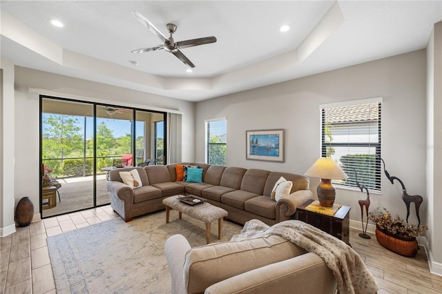 11125 Mcdermott Ct, Englewood, FL 34223 - living room with light wood finished floors, a raised ceiling, a ceiling fan, baseboards, and recessed lighting