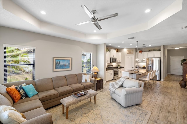 11125 Mcdermott Ct, Englewood, FL 34223 - living room with visible vents, recessed lighting, a tray ceiling, a ceiling fan, and light wood finished floors