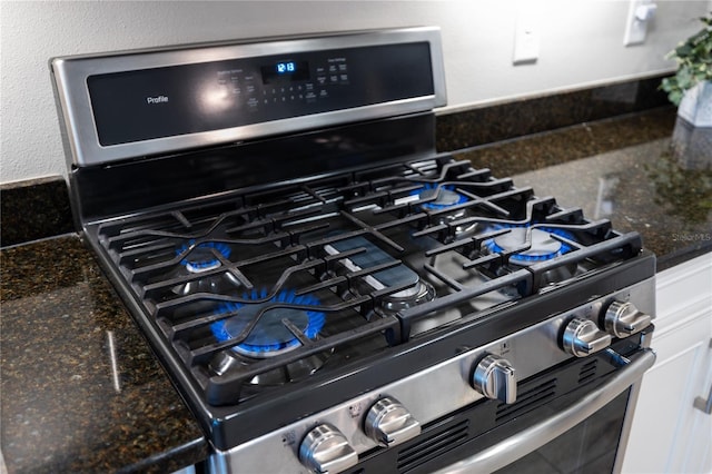 11125 Mcdermott Ct, Englewood, FL 34223 - details with white cabinets, dark stone countertops, and gas range