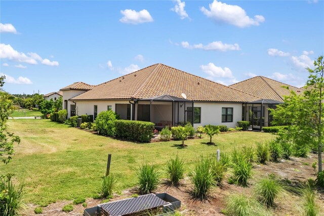 11125 Mcdermott Ct, Englewood, FL 34223 - rear view of property featuring a lanai, a yard, stucco siding, and a tiled roof