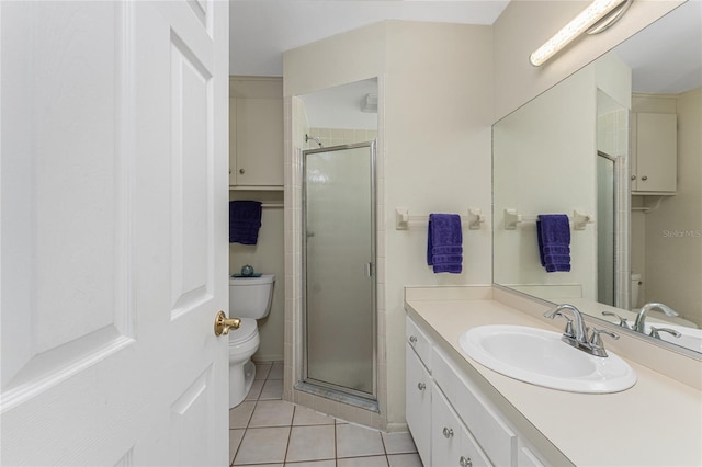 bathroom with vanity, tile patterned floors, toilet, and a shower stall