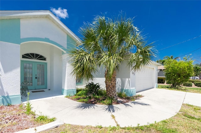 162 Fairway Rd, Rotonda West, FL 33947 - doorway to property with french doors, stucco siding, driveway, and a garage
