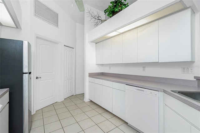 162 Fairway Rd, Rotonda West, FL 33947 - kitchen with light tile patterned floors, freestanding refrigerator, white cabinetry, and dishwasher