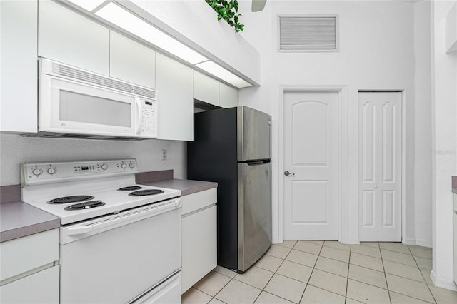 162 Fairway Rd, Rotonda West, FL 33947 - kitchen with white appliances, white cabinetry, visible vents, and light tile patterned flooring