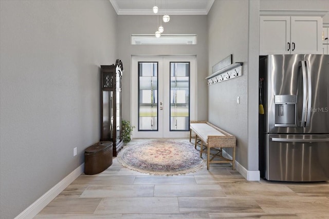 foyer featuring crown molding, baseboards, french doors, and light wood-type flooring