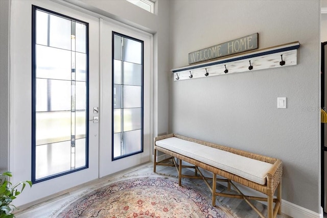 mudroom featuring baseboards, french doors, and wood finished floors