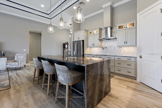 kitchen with crown molding, decorative backsplash, visible vents, a breakfast bar area, and stainless steel refrigerator with ice dispenser