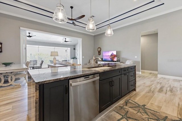 kitchen with a ceiling fan, open floor plan, a raised ceiling, a sink, and dishwasher