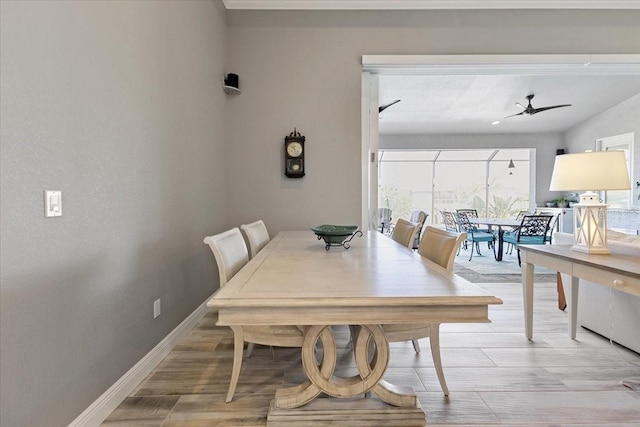 dining area featuring ceiling fan, baseboards, and light wood-type flooring