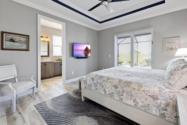 bedroom with a raised ceiling, baseboards, ornamental molding, ensuite bathroom, and light wood-style flooring