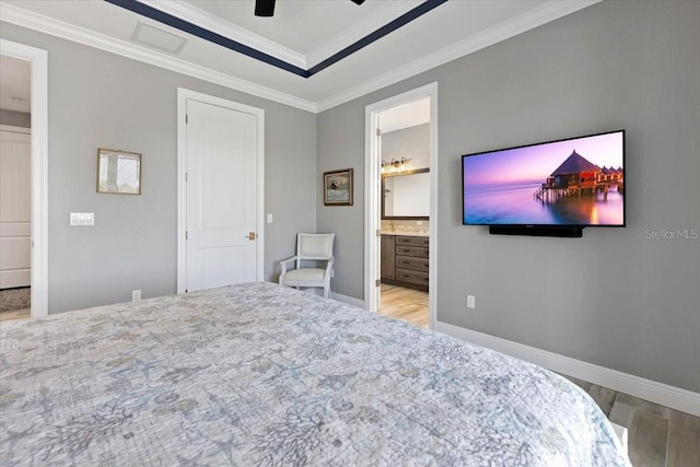 bedroom with crown molding, baseboards, and wood finished floors