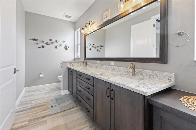 full bath with visible vents, a sink, baseboards, and toilet