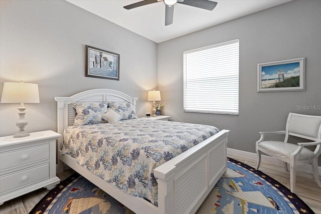 bedroom featuring baseboards, ceiling fan, and wood finished floors