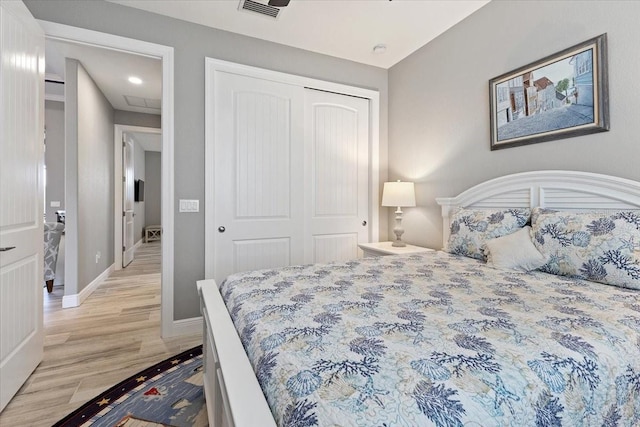bedroom with light wood-style flooring, recessed lighting, baseboards, visible vents, and a closet