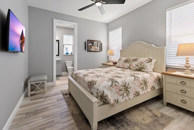 bedroom with light wood-type flooring, baseboards, ensuite bathroom, and ceiling fan