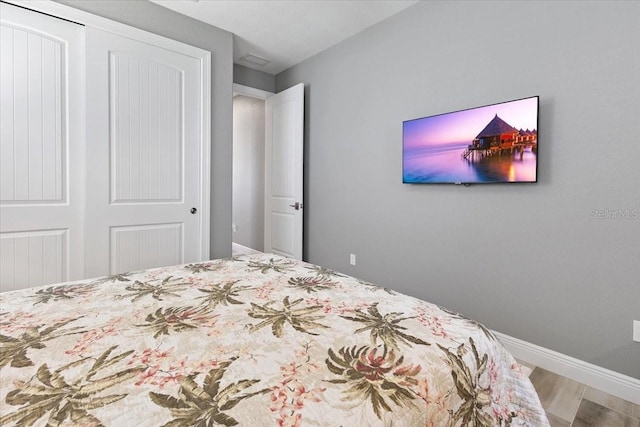 bedroom featuring baseboards, a closet, and wood finished floors