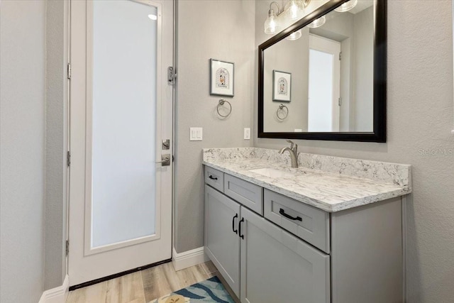bathroom with vanity, baseboards, and wood finished floors