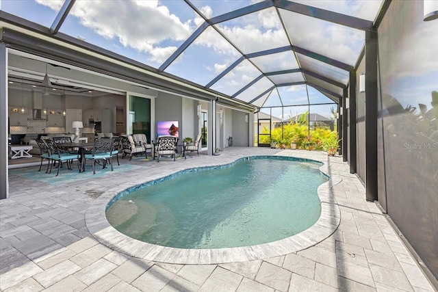 pool featuring glass enclosure and a patio area