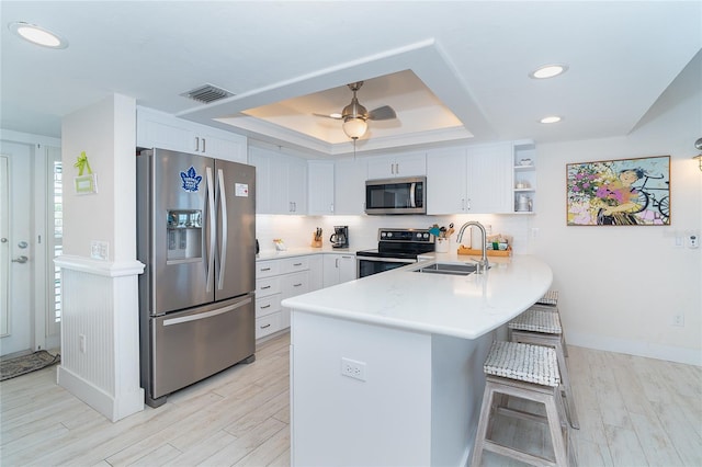 7548 Palm Island Dr S Unit 1724, Placida, FL 33946 - kitchen featuring a tray ceiling, visible vents, a sink, a peninsula, and stainless steel appliances