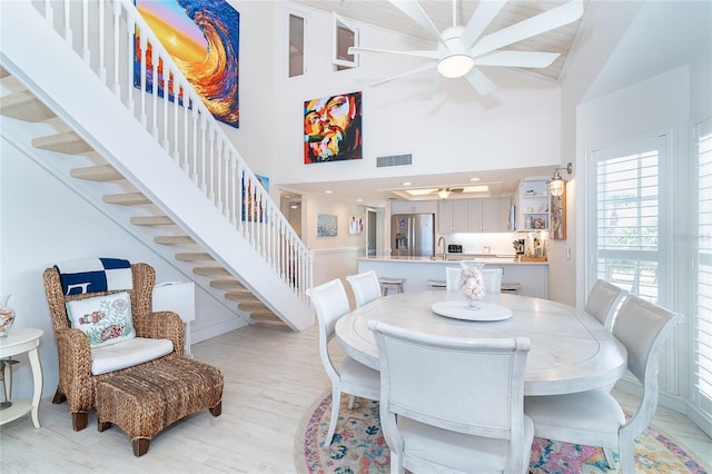 7548 Palm Island Dr S Unit 1724, Placida, FL 33946 - dining space with a ceiling fan, visible vents, light wood-type flooring, stairway, and high vaulted ceiling