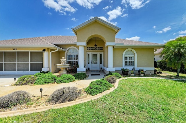 mediterranean / spanish-style home with stucco siding and a front lawn