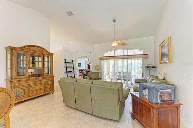 living area featuring a ceiling fan, visible vents, arched walkways, light tile patterned floors, and high vaulted ceiling