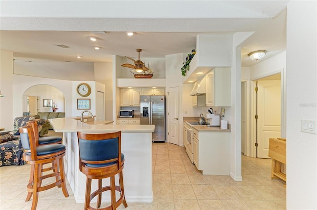 kitchen with light countertops, appliances with stainless steel finishes, light tile patterned flooring, and extractor fan