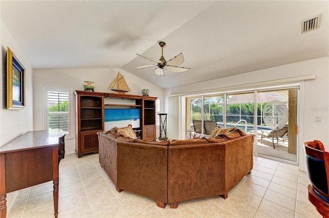 living room with visible vents, ceiling fan, light tile patterned floors, and lofted ceiling
