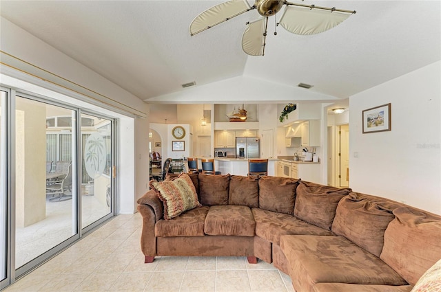 living area with visible vents, ceiling fan, lofted ceiling, and light tile patterned floors