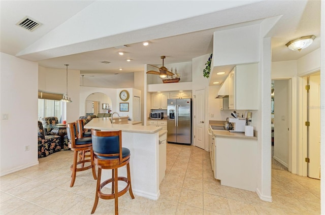 kitchen featuring visible vents, light countertops, light tile patterned floors, vaulted ceiling, and stainless steel appliances