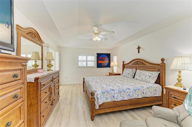 bedroom with a ceiling fan, baseboards, and light wood-style flooring
