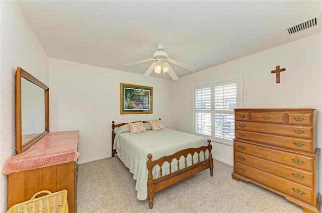 bedroom with baseboards, visible vents, and light carpet