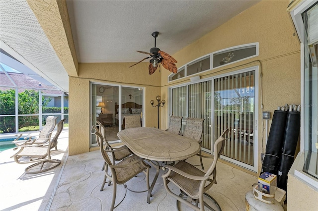view of patio with glass enclosure, ceiling fan, and an outdoor pool