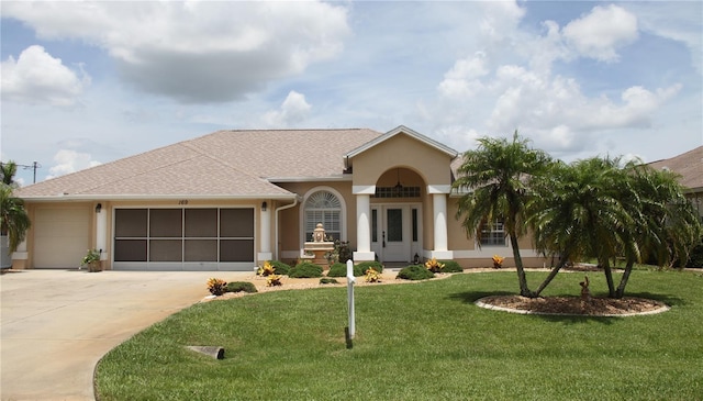 169 Fairway Rd, Rotonda West, FL 33947 - view of front of house with driveway, a garage, stucco siding, and a front lawn