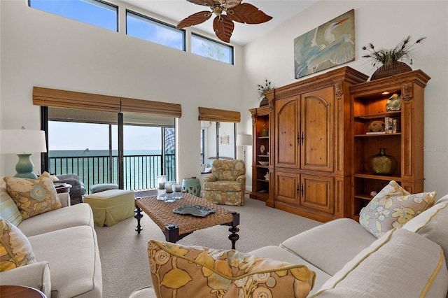 2950 N Beach Rd Unit B324, Englewood, FL 34223 - living area featuring a water view, ceiling fan, light colored carpet, and a towering ceiling