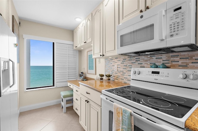 2950 N Beach Rd Unit B324, Englewood, FL 34223 - kitchen featuring white appliances, baseboards, light countertops, backsplash, and a wealth of natural light