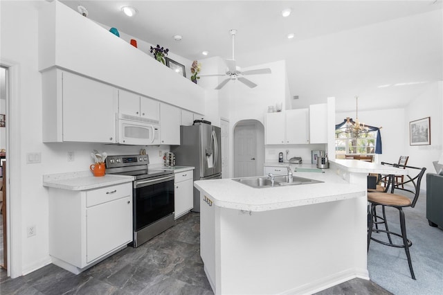 kitchen featuring a sink, appliances with stainless steel finishes, a kitchen breakfast bar, and light countertops