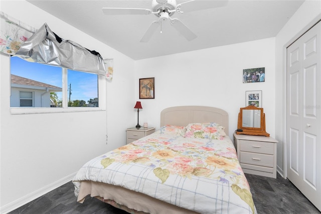 bedroom featuring baseboards, ceiling fan, a closet, and dark wood-style flooring
