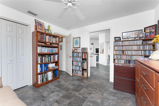 interior space with visible vents and ceiling fan