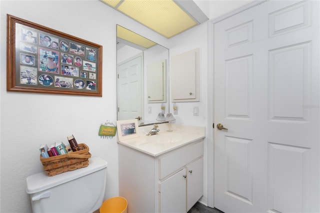 half bathroom featuring vanity and toilet