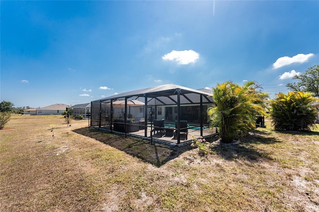 rear view of house with a lawn, a lanai, an outdoor pool, and a patio area