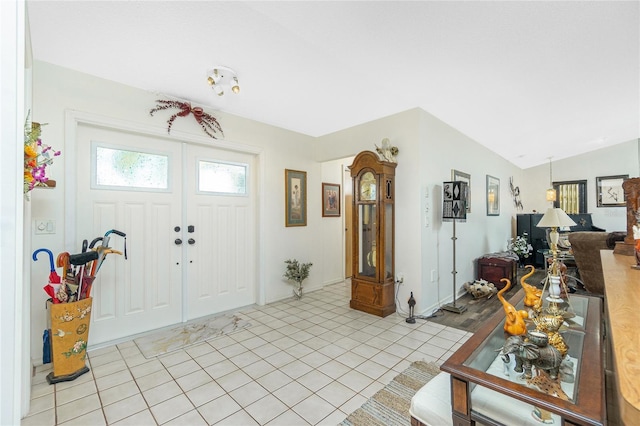 foyer featuring light tile patterned floors and lofted ceiling