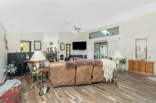 living area with vaulted ceiling, a ceiling fan, and wood finished floors