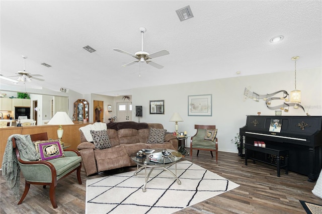 living room with a ceiling fan, a textured ceiling, and visible vents