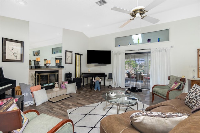 living room featuring visible vents, wood finished floors, lofted ceiling, a fireplace, and ceiling fan