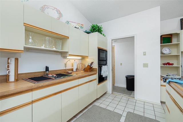 kitchen featuring open shelves, vaulted ceiling, light countertops, light tile patterned floors, and white cabinetry