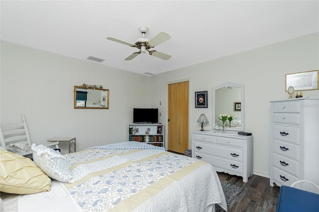 bedroom featuring a ceiling fan, dark wood-style floors, a textured ceiling, and visible vents