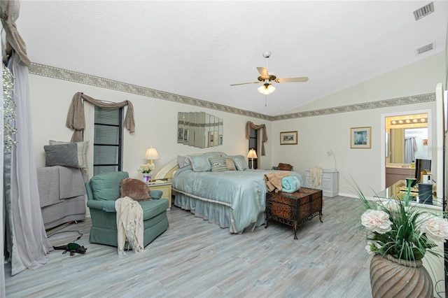 bedroom with light wood-style floors, vaulted ceiling, and visible vents