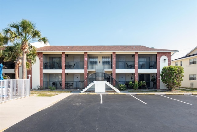 1531 Placida Rd Unit 4-103, Englewood, FL 34223 - view of property featuring stairs, uncovered parking, and fence